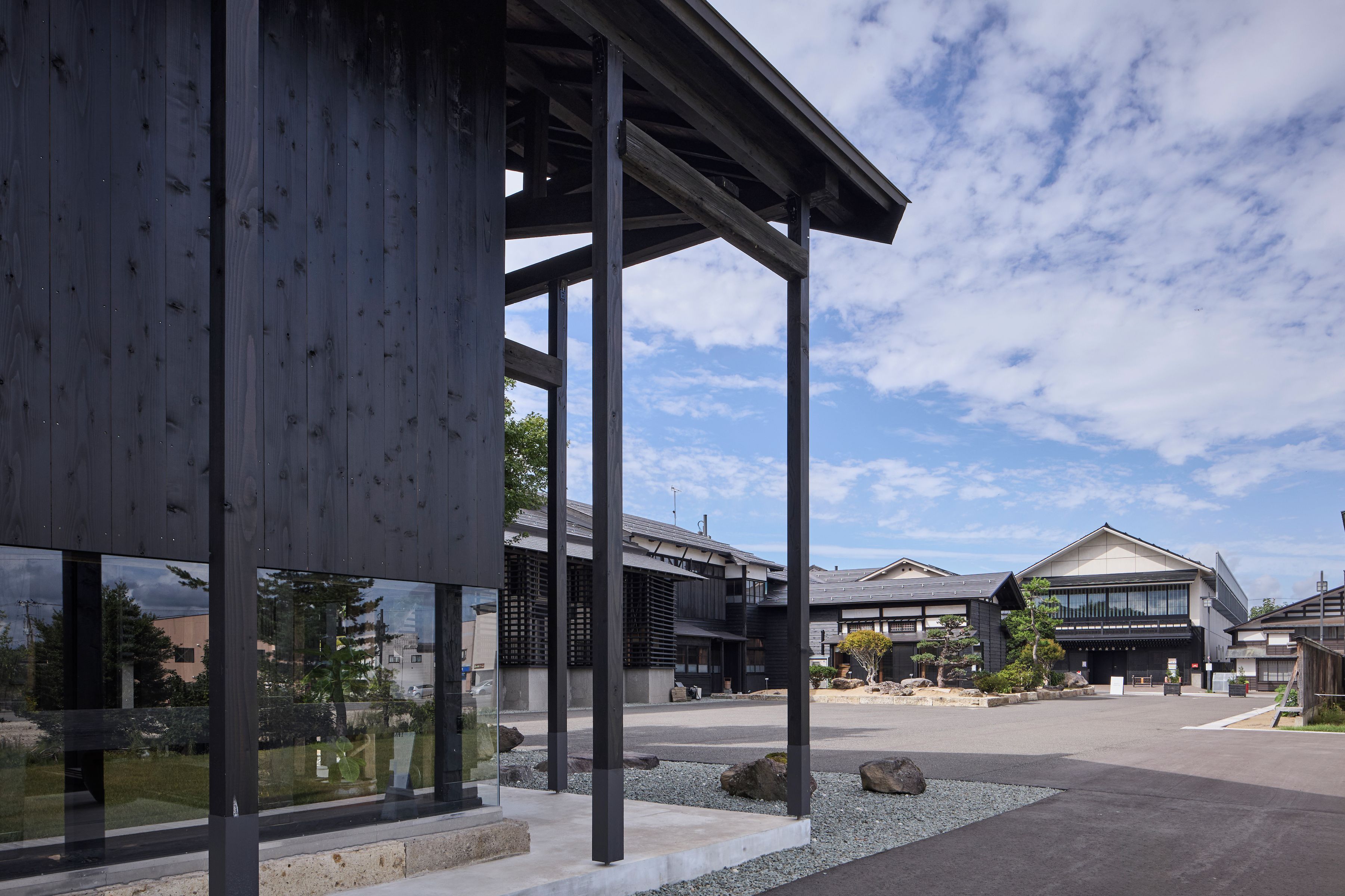 A modern building with large windows and a covered outdoor area.