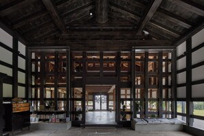 Un interior japonés tradicional con suelo de tatami, vigas de madera y puertas correderas.