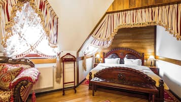 A bedroom with a wooden bed, a wooden bench, a radiator, and a window with curtains.