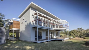 A modern two-story house with a balcony, large windows, and a covered outdoor area. - Anchor at Bawley Point (Bawley Point)