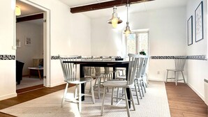 A dining area with a black table, white chairs, and a patterned rug. - 5 bedroom pet friendly home in Sjöbo (Sjöbo)