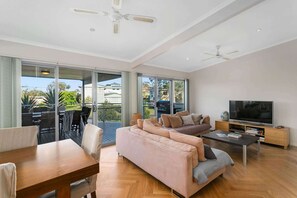 A spacious living area with a sofa, TV, and dining table. - Dream Weaver at Bawley Point (Bawley Point)