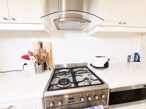 A kitchen with a gas stove, a toaster, and a microwave. - Blue Chill of Mollymook (Mollymook Beach)