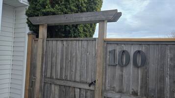 A wooden gate with the number '100' on a property.