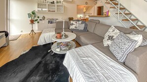 A modern living room with a sofa, coffee table, and a staircase.