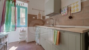 Eine Küche mit Spüle, Schränken und einem Fenster mit Vorhang.