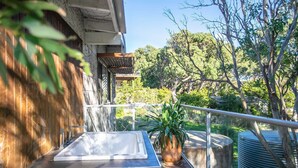 A rooftop terrace with a hot tub, potted plants, and a view of trees and greenery. - Sea Forever at Kioloa (Kioloa)