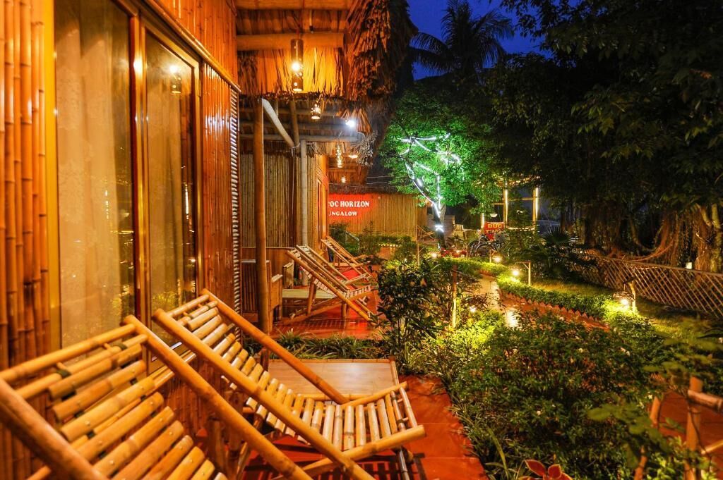 A hotel with a thatched roof, bamboo railings, and a sign reading 'OC HORIZON JUNGALOW.'