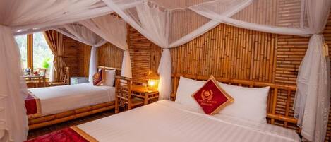 Una habitación con dos camas, cabecero de madera, almohada roja y dosel.