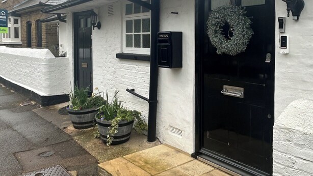 A white building with a black door, a post box, and a wreath on the door. - Stylish Home with full Amenities (Uxbridge)