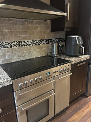 A kitchen with a stainless steel stove, oven, and coffee maker on the countertop. - Stylish Home with full Amenities (Uxbridge)