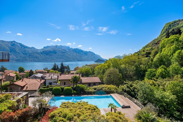 A residential area with a swimming pool, houses, and a lake with mountains in the background. - Magical Menaggio Vista (Menaggio)