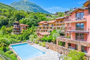 Un complex turístic amb piscina, diversos balcons i un paisatge de muntanyes.