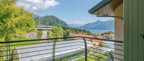 Ein Balkon mit Blick auf einen Berg, ein Gewächshaus und eine Brücke.