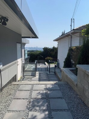 Un edificio moderno con un camino de piedra que conduce a una puerta de vidrio.