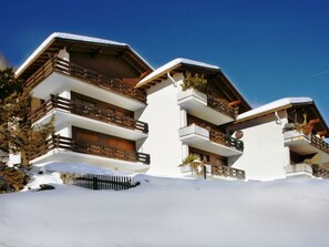 Ein mehrstöckiges Gebäude mit Balkonen, umgeben von Schnee.