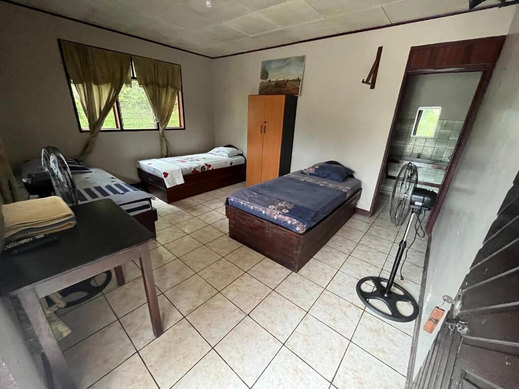 A room with a bed, a desk, a wardrobe, and a mirror.