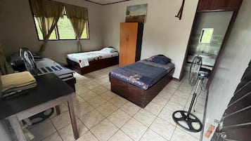 A room with a bed, a desk, a wardrobe, and a mirror.