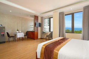 Ein Hotelzimmer mit Bett, Schreibtisch, Fernseher und einem Fenster mit Blick.