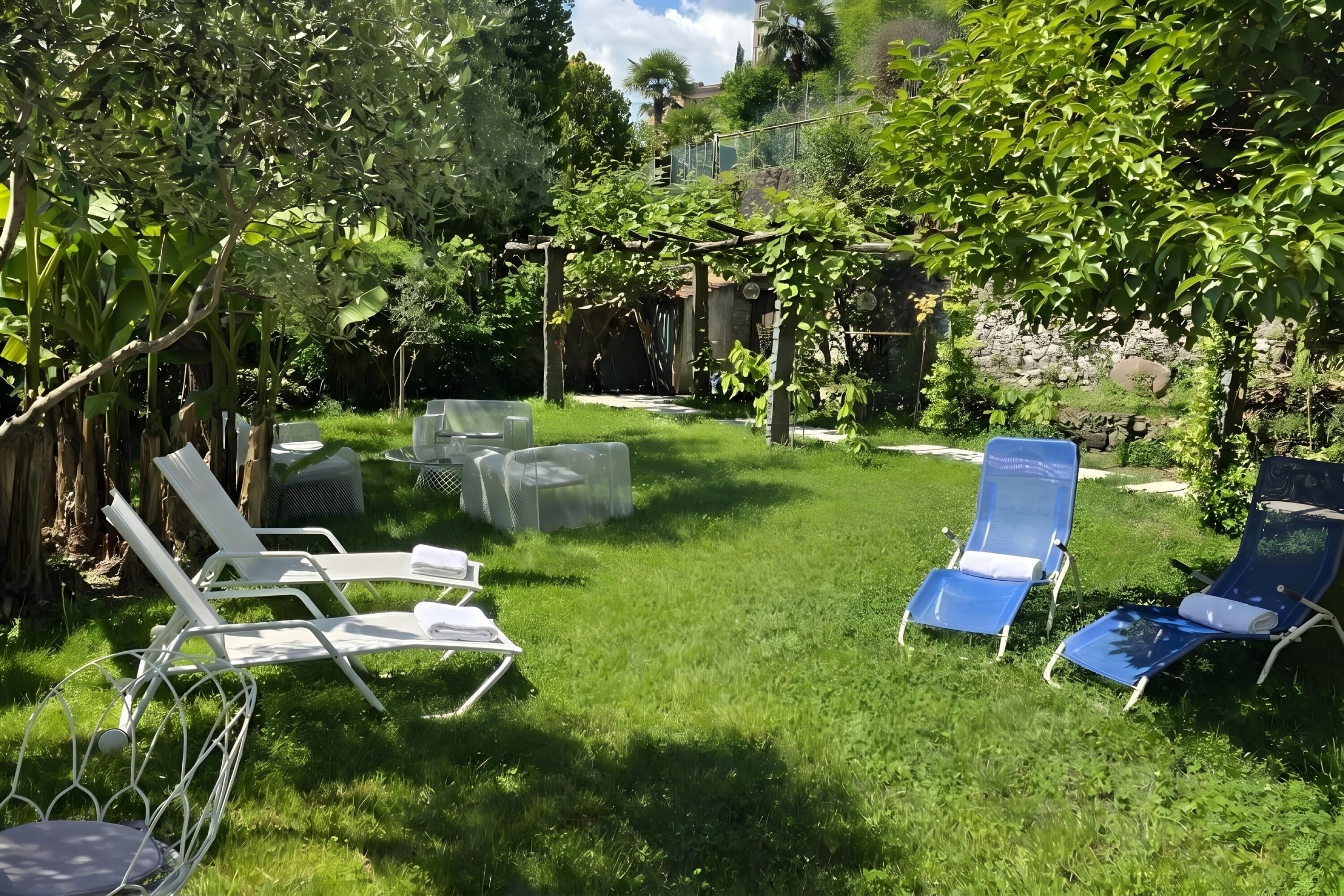 A backyard with a pergola, two blue lounge chairs, and a white chair.