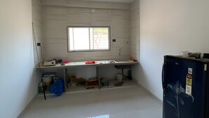 Een kamer met een raam, een wastafel, een koelkast en een betegelde vloer.