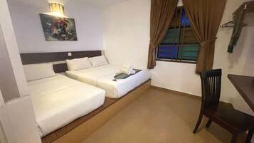 A hotel room with two beds, a desk, a chair, a painting, and a window with curtains.