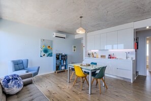 Ein moderner Wohnraum mit Essbereich, Küche und Sitzgelegenheiten.