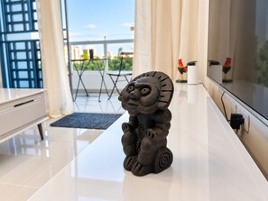 A room with a white table, a statue, a window, and a view of greenery outside. - The Duo by Suarez Properties | Jacuzzi & BBQ (Santo Domingo Este)