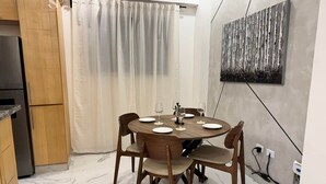 A dining area with a round table, six chairs, and a curtain. - The Duo by Suarez Properties | Jacuzzi & BBQ (Santo Domingo Este)