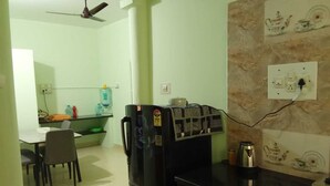 A kitchen with a refrigerator, a coffee machine, and a water dispenser on the counter.