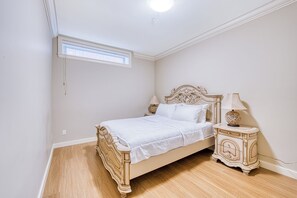 Ein Schlafzimmer mit Bett, Nachttischen und einem Fenster.