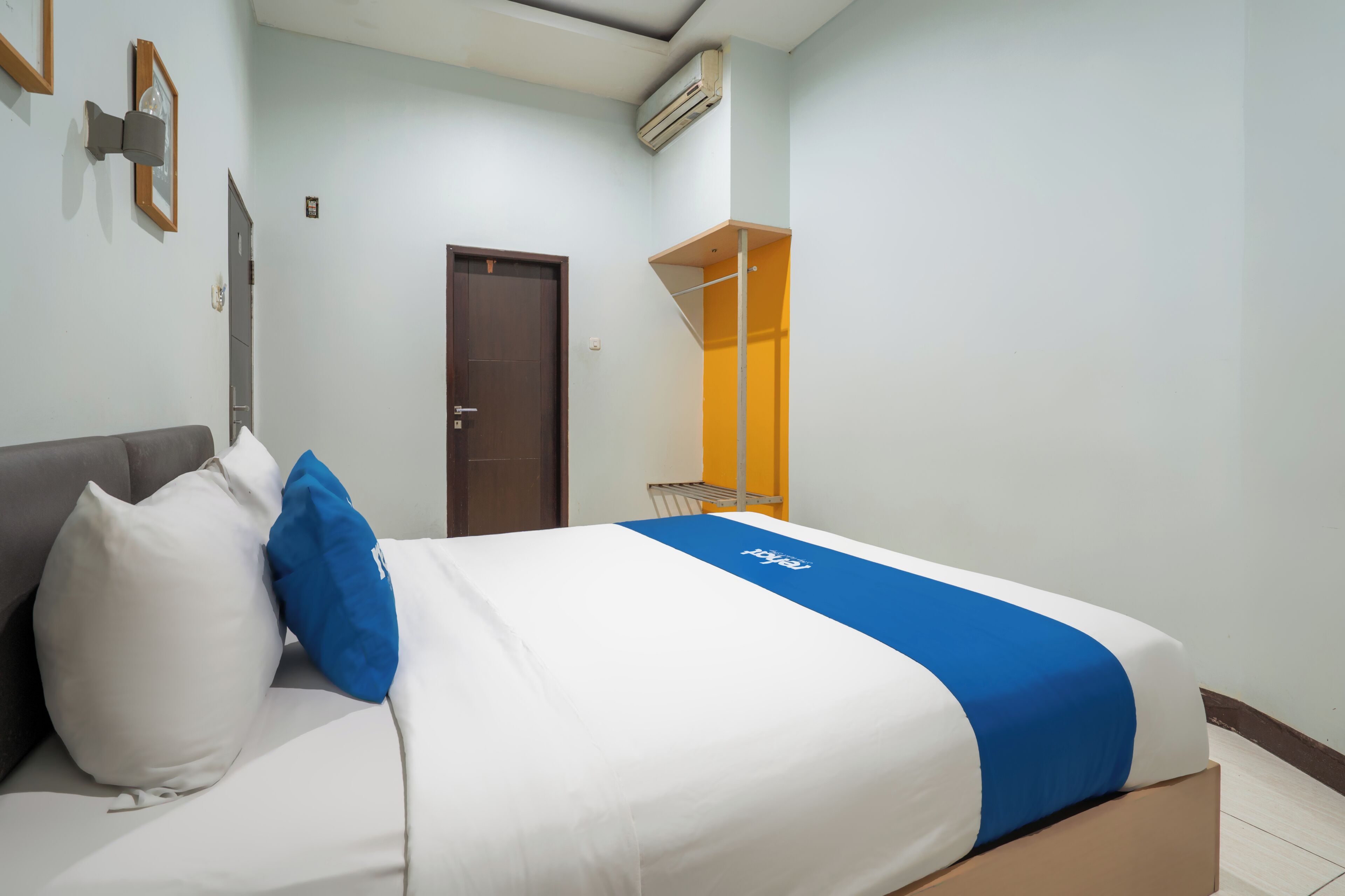 Une chambre d’hôtel équipée d’un lit, d’une armoire, d’une porte et d’un appareil de climatisation.