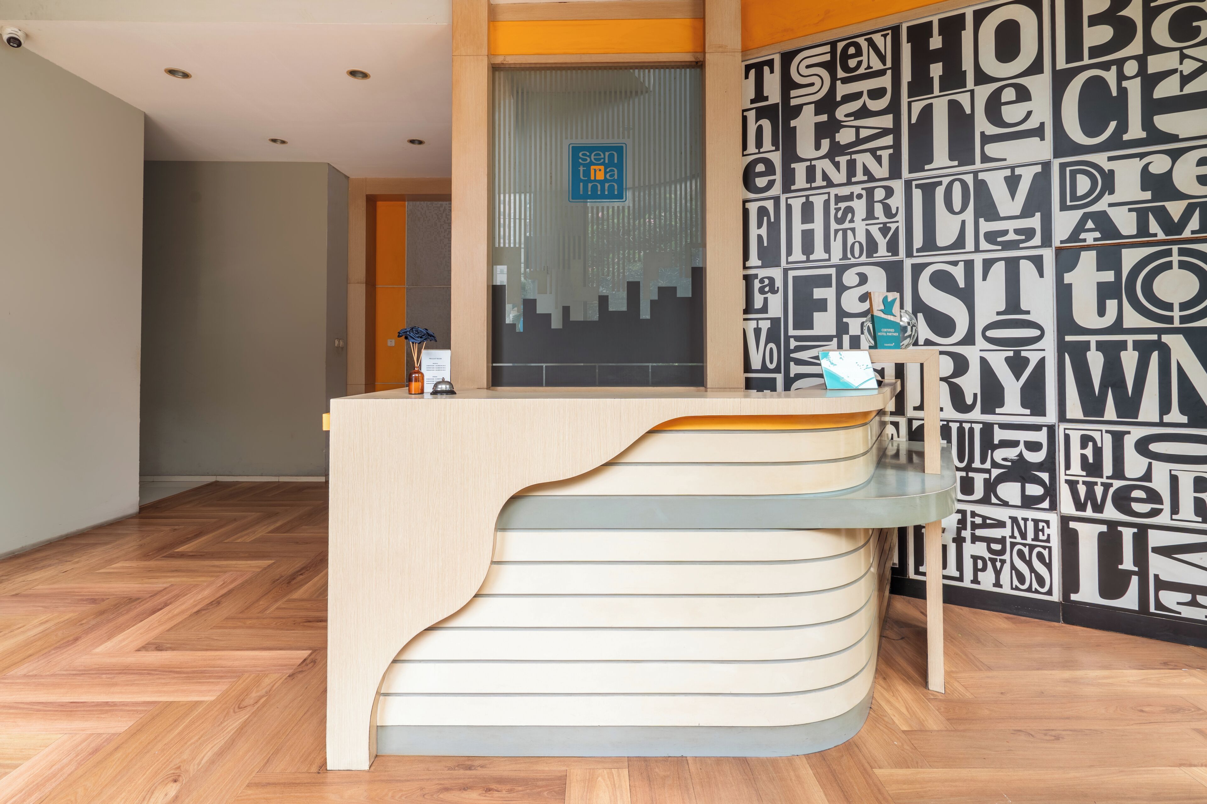 A reception desk with a modern design, a sign for 'sen tima inn,' and a wall with large, bold typography.
