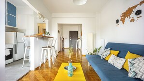 A modern living room with a blue sofa, yellow ottoman, and a wooden coffee table. - Amazing Acropolis View From A Sunny Renovated Apt in Athens! (Athina)