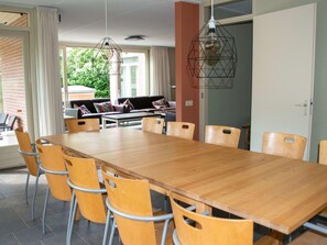 Ein Essbereich mit einem langen Holztisch, sechs Stühlen und zwei Pendelleuchten.