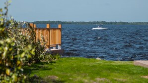Uitzicht op het water met een houten terras en een boot.