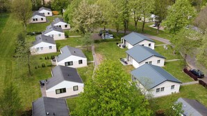 Un quartier résidentiel composé de plusieurs maisons, chacune ayant un style de toit distinct et étant entourée de verdure.