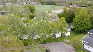 Un quartiere residenziale con case, prati verdi e alberi.