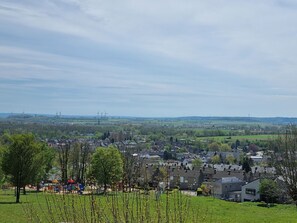 A residential area with houses, a playground, and wind turbines in the distance. - Bungalowpark Simpelveld - Castra 47 by Interhome (Simpelveld)
