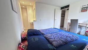 Une chambre à coucher avec un lit, des oreillers, un bureau et une chaise.