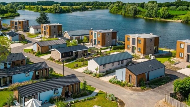 Zona residencial con casas modernas, un río y cielo despejado.