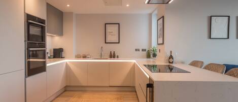 A modern kitchen with built-in appliances, a central island, and a minimalist design.