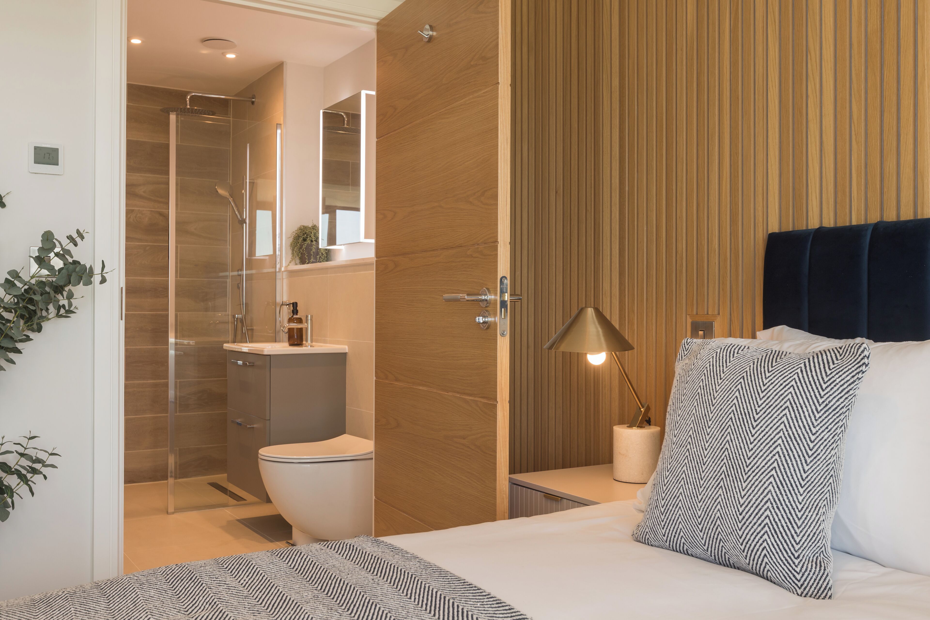 A modern bathroom with a shower, toilet, and sink.
