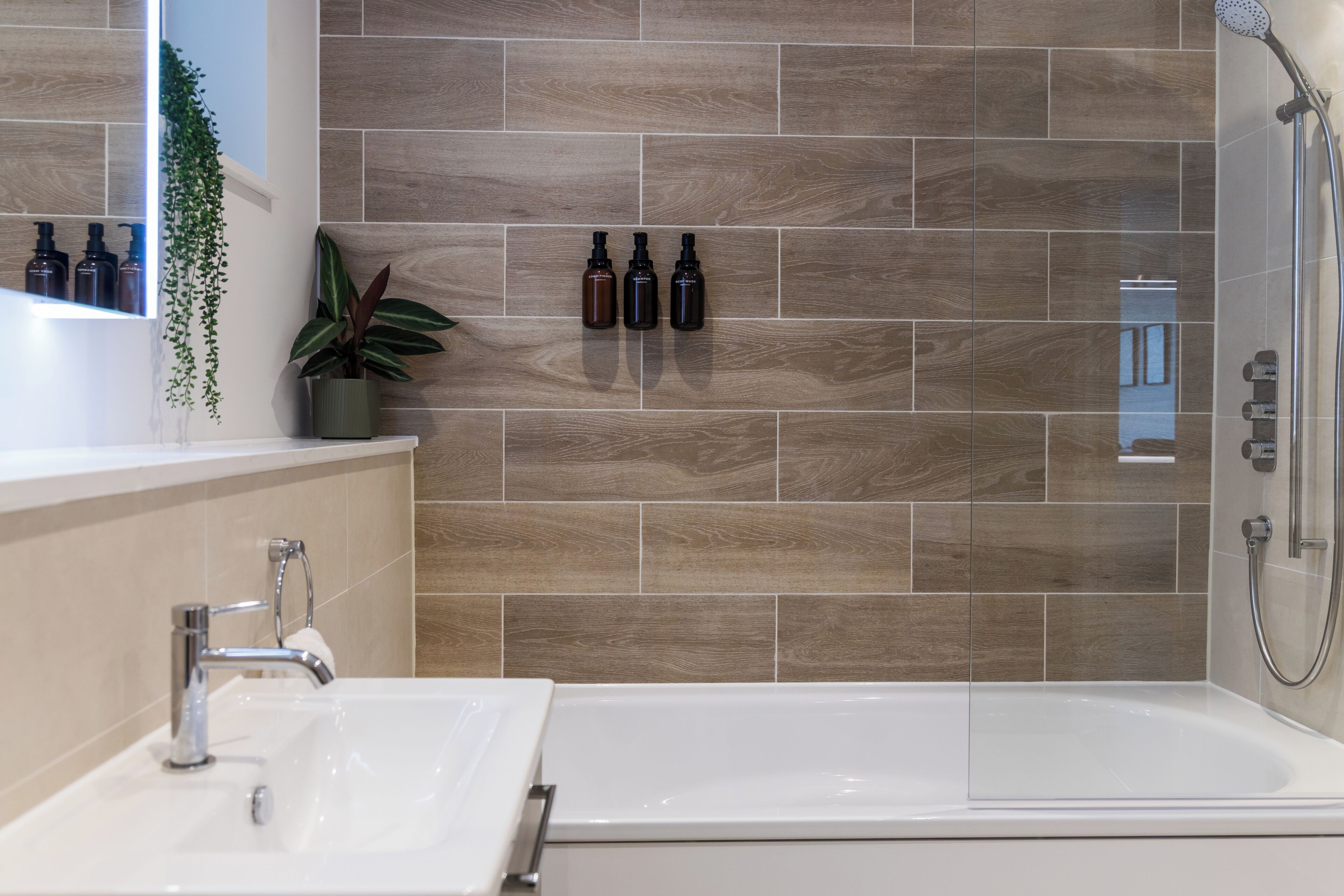 A modern bathroom with a bathtub, a sink, and a shower.