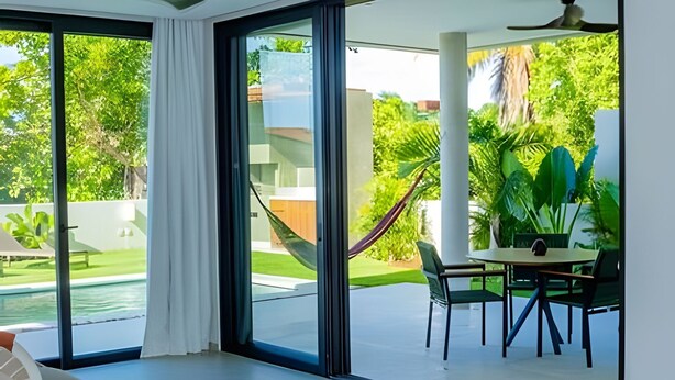 A modern room with a large sliding glass door, a pool, and a dining area with chairs and a table. - Vila Manga Rosa (Tibau do Sul)