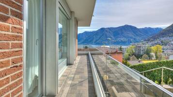 Un balcone con vista sulle montagne e su un lago.