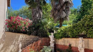 Ein Innenhof mit Steintreppe, Blumentöpfen und Statuen.