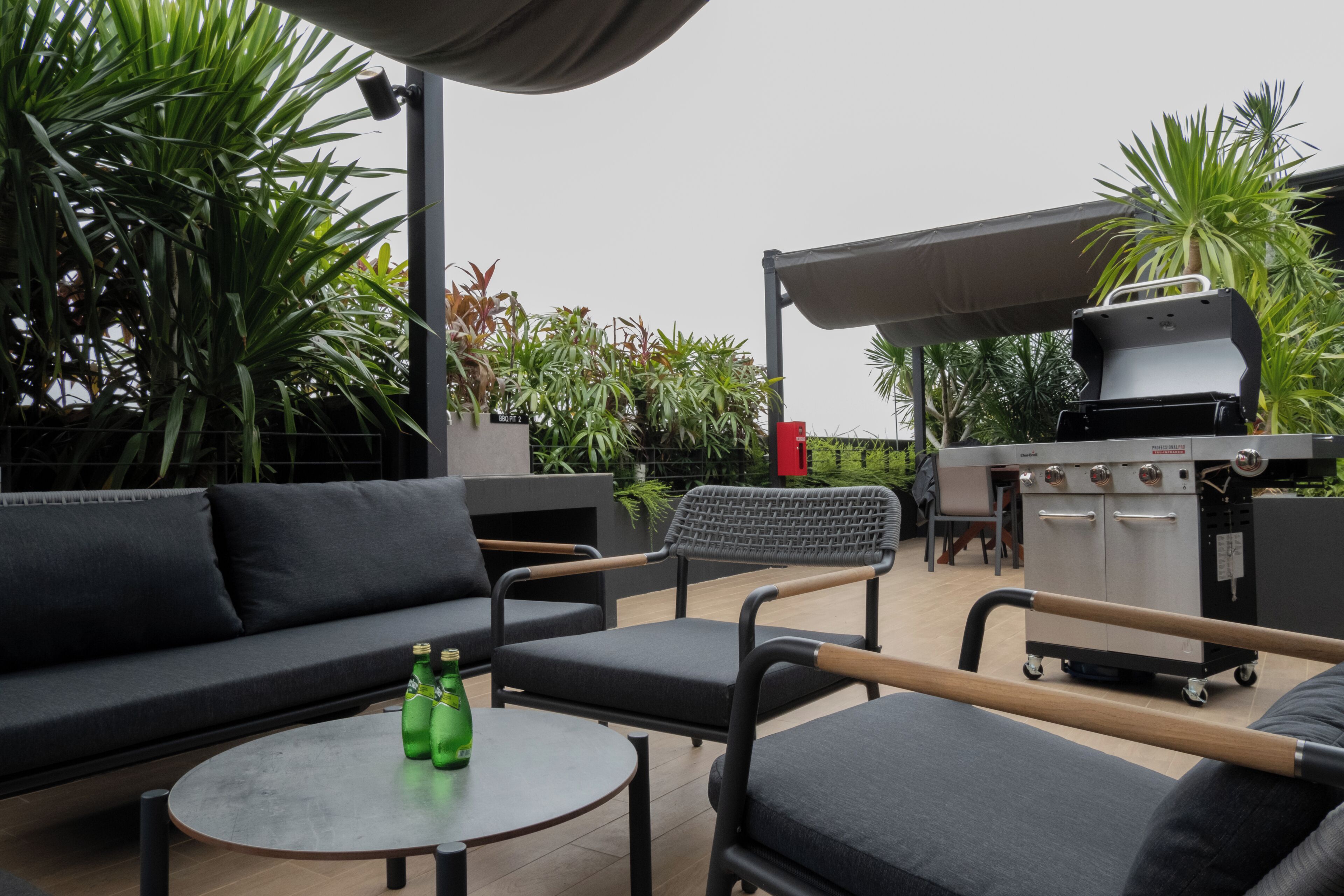 An outdoor seating area with a sofa, chairs, and a round table.