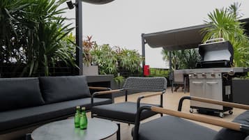 An outdoor seating area with a sofa, chairs, and a round table.