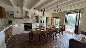 Une cuisine équipée d’une table à manger, de chaises, d’une cuisinière et d’un réfrigérateur.